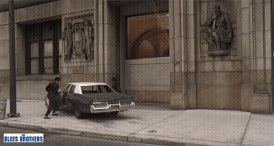 Man Getting Out of Car With Blues Brothers Sign