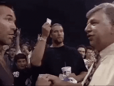 Man Giving Card To Another Man In Crowd GIF