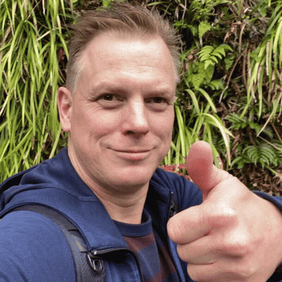 Man Giving Thumbs Up In Front Of Plant Wall GIF