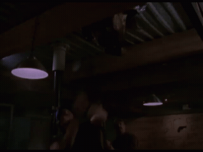 Man Hanging Upside Down From Pole In Dark Room GIF
