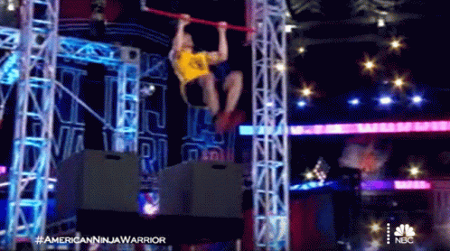 Man Hanging Upside Down On Bar In NBC Advertisement GIF