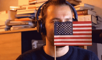Man Hiding Behind Small American Flag With Headphones GIF