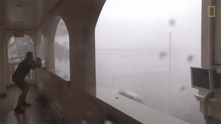 Man Hiding From Strong Winds Of Bomb Cyclone GIF