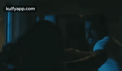 Man Holding Another Man In Dark Room GIF