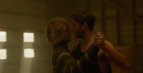 Man Holding Another Man While Dancing In Dark Room GIF