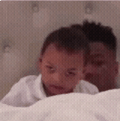 Man Holding Baby Laying On Bed GIF