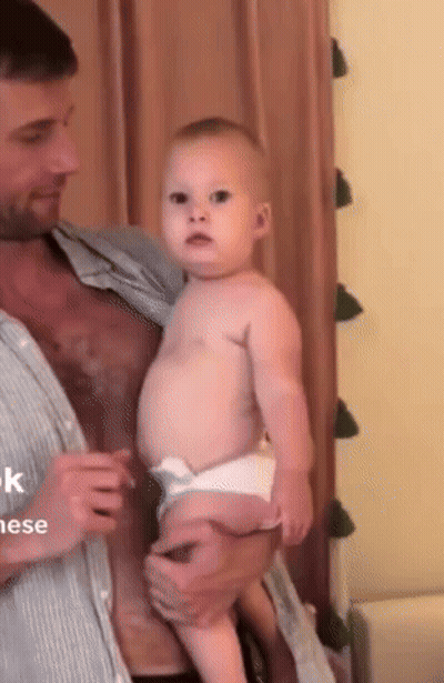 Man Holding Baby Looking At Camera GIF
