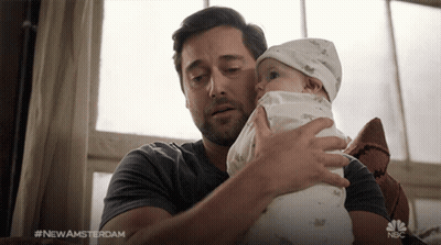 Man Holding Baby With NBC Logo Behind GIF