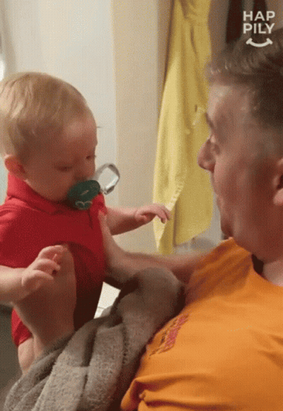 Man Holding Baby With Pacifier Saying Happily GIF