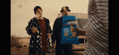 Man Holding Bag of Chips With Two Others