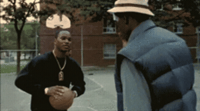 Man Holding Basketball Talks To Man In Hat GIF