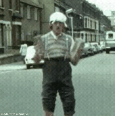 Man Holding Book In Street Wearing Suspenders GIF
