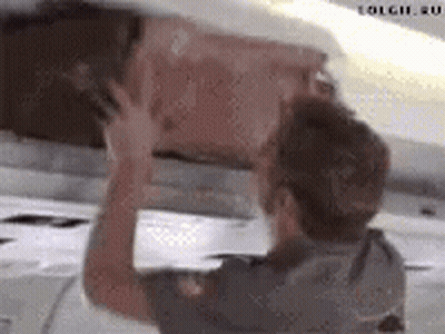 Man Holding Box Under Plane GIF