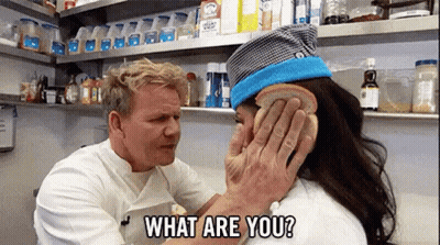 Man Holding Bread Over Woman's Ear Asking What Are You GIF