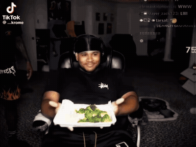 Man Holding Broccoli In Front Of TikTok Screen GIF