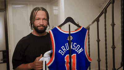 Man Holding Bruins Jersey On Hanger GIF