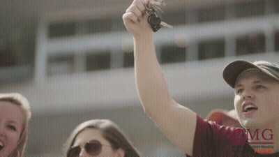 Man Holding Car Key In Front Of MG Building GIF