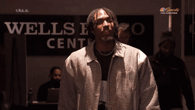 Man Holding Cell Phone In Front Of NBC Sports Philadelphia GIF