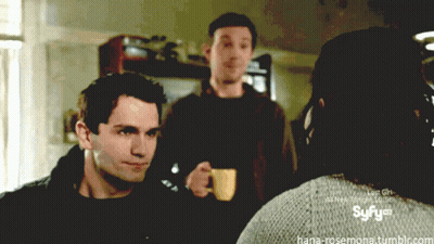 Man Holding Coffee In Front Of Syfy Logo GIF