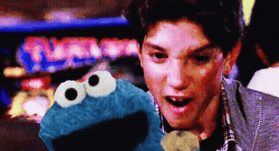 Man Holding Cookie Monster In Front Of Turbo Pinball Machine GIF