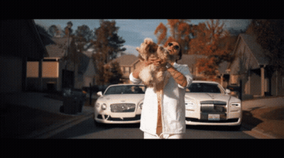 Man Holding Dog In Front Of Two Bentleys GIF