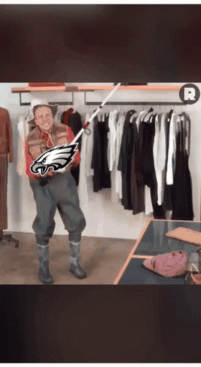 Man Holding Fishing Rod With Eagles Logo GIF