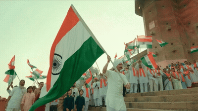 Man Holding Flag In Front Of Crowd GIF