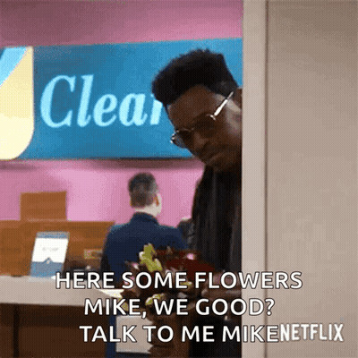 Man Holding Flowers In Front Of Sign GIF