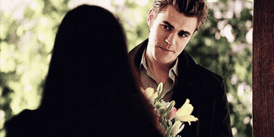 Man Holding Flowers Looking At Woman GIF