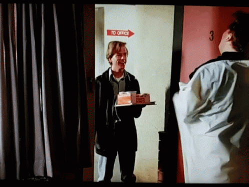Man Holding Food Tray In Front Of Red Office Door GIF
