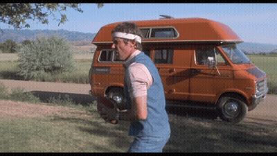 Man Holding Football Beside Orange Van RV GIF