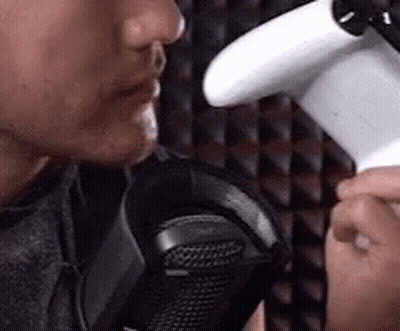 Man Holding Game Controller Talking Into Microphone GIF