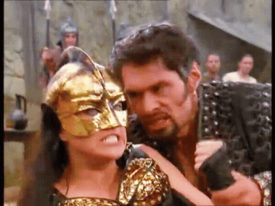 Man Holding Gun And Woman Wearing Mask GIF