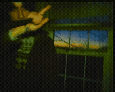 Man Holding Gun In Dark Room With SS Graffiti GIF
