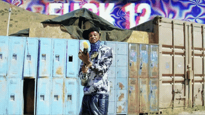 Man Holding Gun In Front Of Block 12 Wall GIF