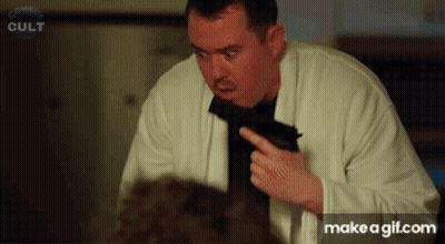 Man Holding Gun In Front Of Comedy Cult Screen GIF