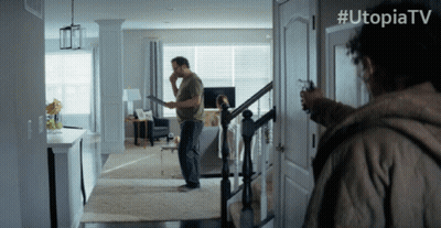 Man Holding Gun In Front Of Door With Utopiatv GIF