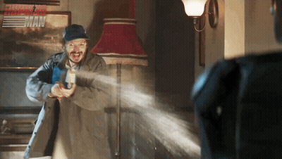 Man Holding Gun In Front Of Fast And Furious Poster GIF