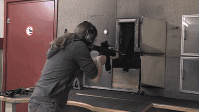 Man Holding Gun In Front Of No Smoking Sign GIF