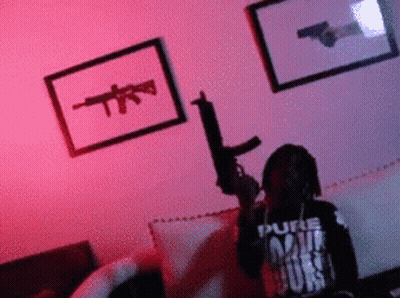 Man Holding Gun In Living Room With Gun Picture On Wall GIF