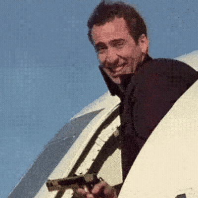 Man Holding Gun Looking Out Plane Window GIF