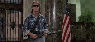 Man Holding Gun Says I Have Come Here To Chew Bubblegum In Front Of American Flag GIF