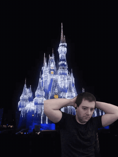 Man Holding Hands Behind Head In Front Of Disney Castle GIF