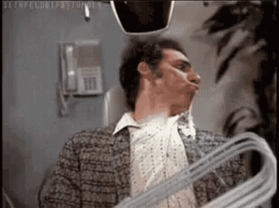 Man Holding Hanger Making Face In Mirror GIF