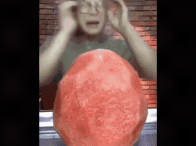 Man Holding Head in Front of Giant Watermelon