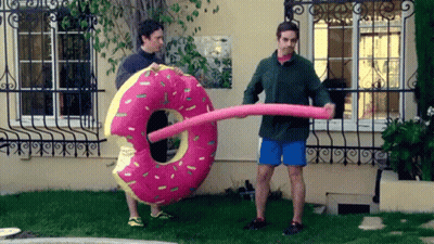 Man Holding Large Pink Donut Float GIF