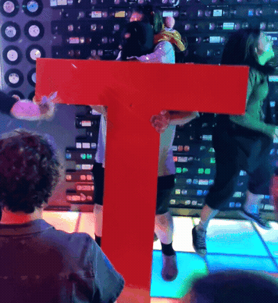Man Holding Large Red Letter T GIF