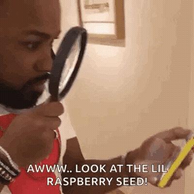 Man Holding Magnifying Glass Looking At Phone GIF
