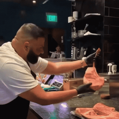 Man Holding Meat In Front Of Exit Sign GIF