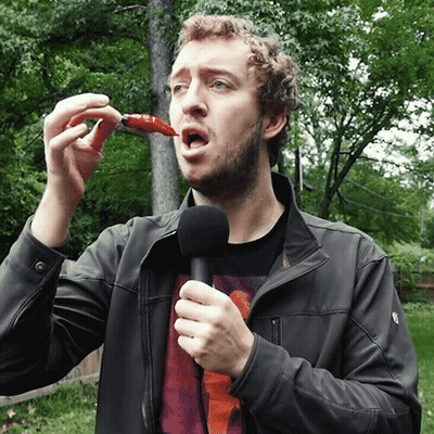 Man Holding Microphone Eating Red Pepper GIF